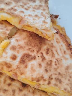 Sajtos-baconös tojásos tortilla 🥓🧀 Hozzávalók: - 2 db tortilla lap - 2 db tojás - Bacon - Lapkasajt - Reszelt sajt - Só, bors Elkészítés: A bacont felcsíkozzuk, majd egy serpenyőben megpirítjuk. A tojásokat sóval, borssal felverjük. Egy tortilla lapot helyezünk a serpenyőbe, majd ráöntjük a felvert tojást. Rátesszük a pirított bacont, a lapkasajtot és a reszelt sajtot. Ezután ráhelyezzük a másik tortilla lapot, és egy kicsit tovább pirítjuk. Óvatosan megfordítjuk, hogy a másik oldala is szépen megpiruljon, és a sajt jól összeolvadjon. Végül pizzaszeletelővel felszeleteljük. #tortilla #breakfastideas  #breakfast  #easyrecipes #gyorsreggeli 